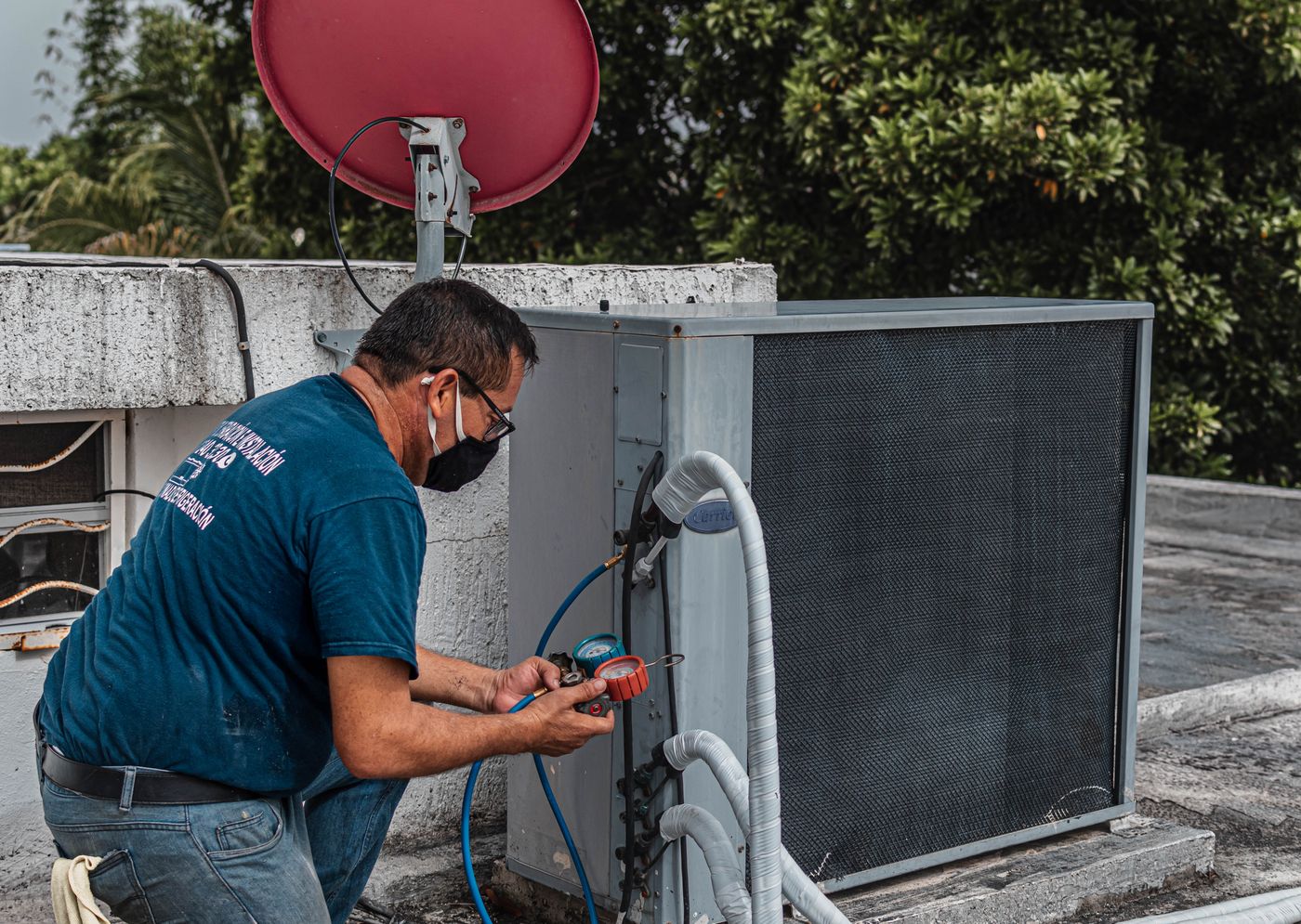 Technician checking an outdoor air conditioning system with service gauges